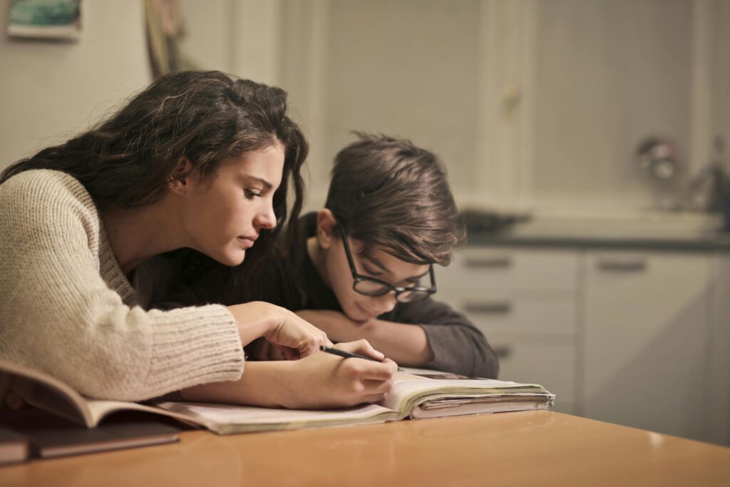 pexels-photo-3769995-3769995 An attentive girl helps her younger brother concentrate on homework in a cozy home setting.